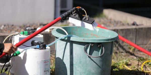 洗浄に使う薬剤・機材の供給体制。独自に開発した薬剤や専用機材を本部から提供し、全国どこでも建物を傷めない高品質な外壁洗浄が可能な仕組みを紹介。専門店の安定した掃除品質を支えるノウハウを表現。