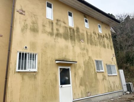 築20年の建物におけるジョリパット外壁の掃除事例。外壁診断士がコケの発生状況を正しく診断し、外壁洗浄専門店WASHERS（ウォッシャーズ）の技術で、素材の風合いを守りながら誠実なメンテナンスを行った様子を表現。