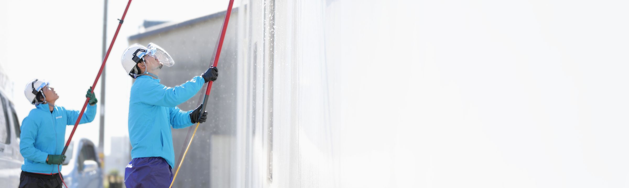 スタッフが外壁洗浄をしている作業風景