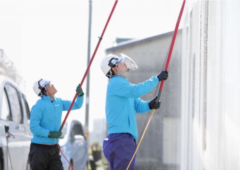 スタッフが外壁洗浄をしている作業風景