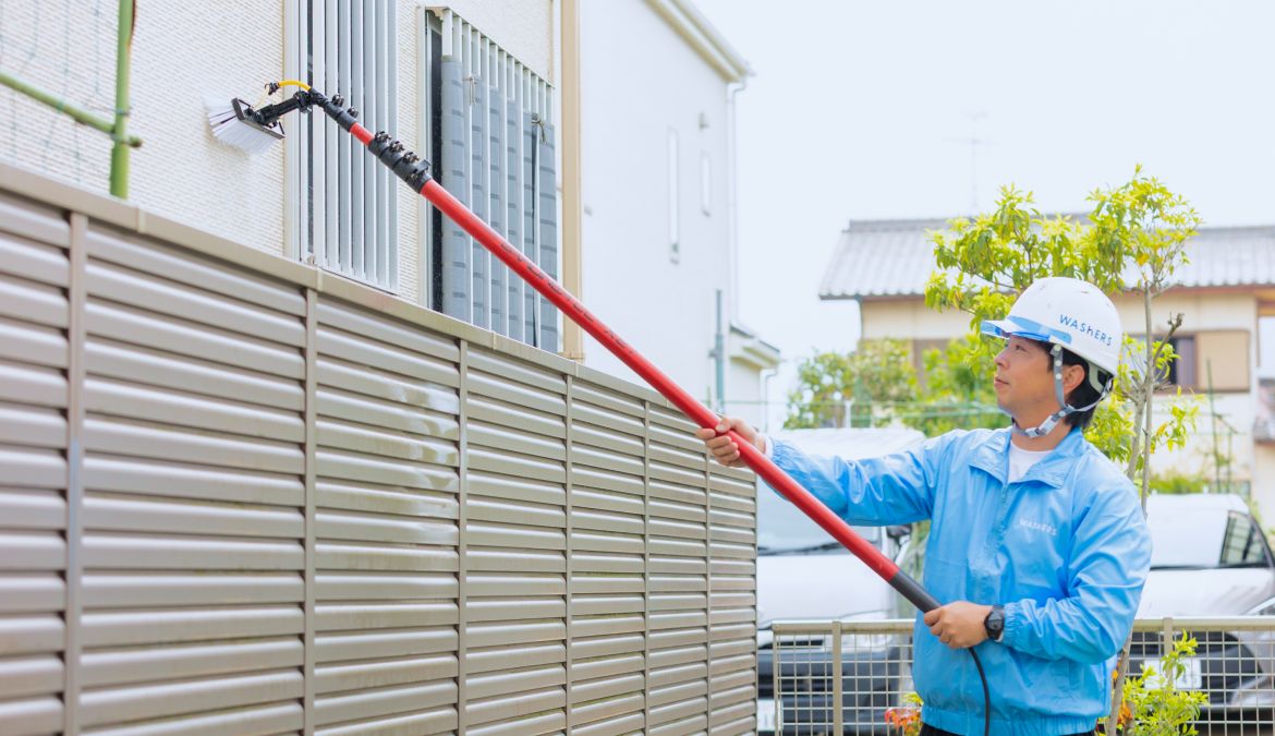 外壁洗浄専門店ウォッシャーズの特徴を紹介するバナー。汚れの程度を問わず、足場を設置せずに高所の掃除を行うスタッフの様子。