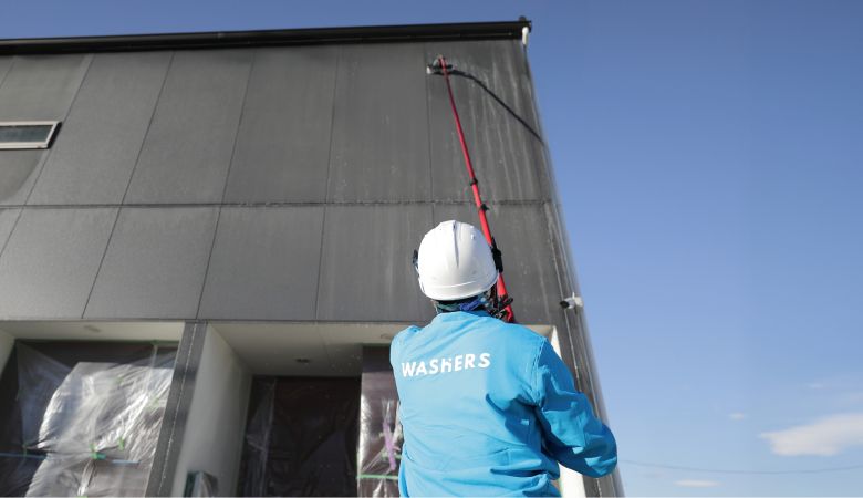 外壁洗浄専門店WASHERS（ウォッシャーズ）の特徴を紹介するバナー。汚れの程度を問わず、足場を設置せずに高所の掃除を行うスタッフの様子。