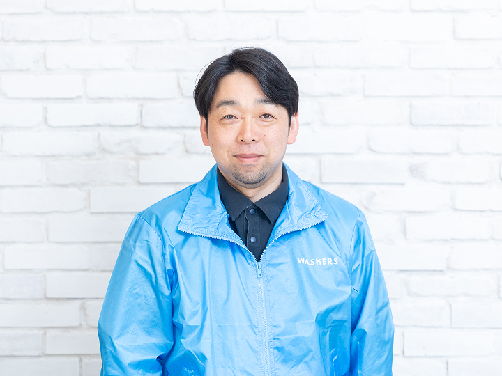 外壁洗浄専門店ウォッシャーズ宮城の店長、渡邊　拓也の様子。地域のホームドクターとして建物の状態を正しく診断し、誠実な掃除をお届けするプロの姿勢を表現。